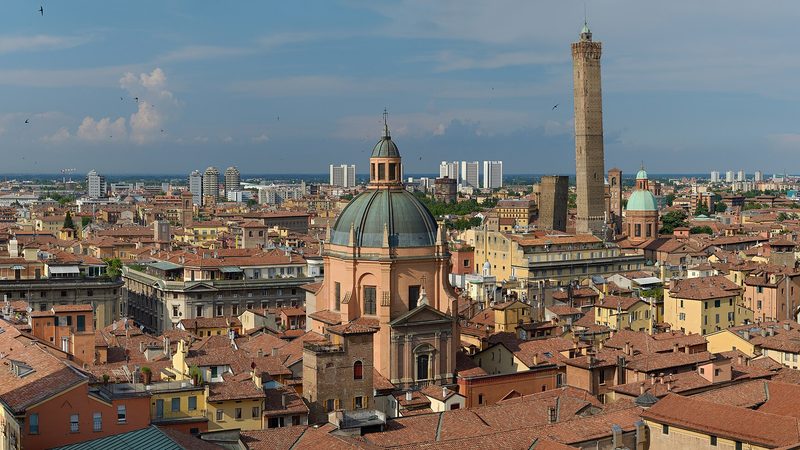 Bologna rooftops and towers, Italy, photographed from San Petronio in 2016; the 2027 host city remains provisional.