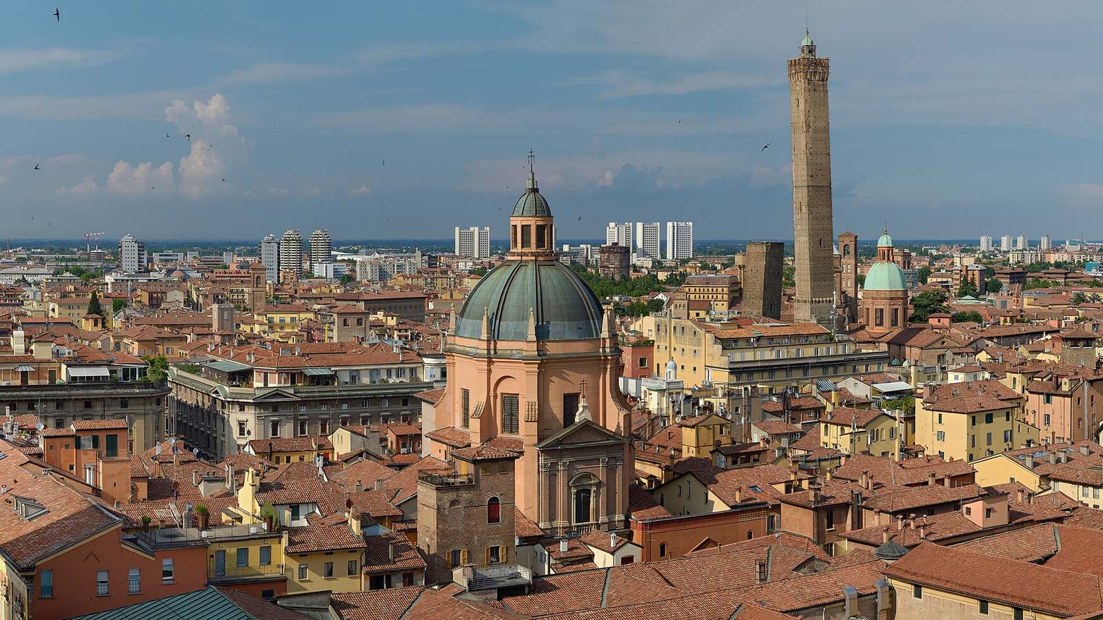 Bologna rooftops and towers, Italy, photographed from San Petronio in 2016; the 2027 host city remains provisional.